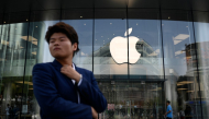 A man looks on as he walks past an Apple store in Beijing on September 23, 2026. (Photo by WANG Zhao / AFP)
