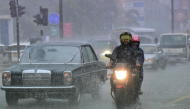 File photo showing commuters driving down a flooded street in Colombo. AFP file photo.