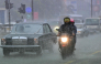 File photo showing commuters driving down a flooded street in Colombo. AFP file photo.