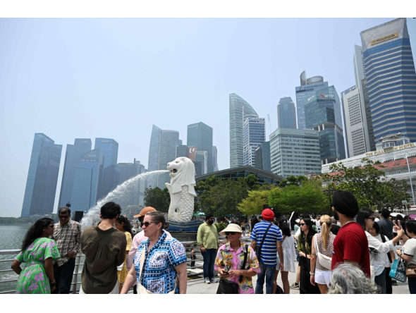 People gather at Marina bay waterfront in Merlion park in Singapore on September 29, 2026. (Photo by Roslan Rahman / AFP)
