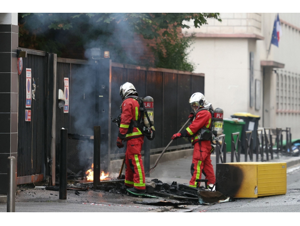 Firefighters extinguish a fire at the entrance of the Leonard de Vinci secondary school following a blockading action by protesting students, in Paris on October 2, 2026. (Photo by Thomas SAMSON / AFP)