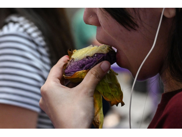 This photo taken on September 23, 2026 shows a customer eating an ube bibingka (baked rice cake) at a mall in Quezon City, Metro Manila. (Photo by Jam Sta Rosa / AFP) 