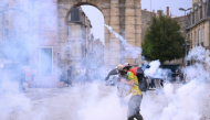 Protesters stand amid tear gas fired by police during demonstration part of a nationwide day of actions called by high-school students in Bordeaux, southwestern France, on October 6, 2026. (Photo by Christophe ARCHAMBAULT / AFP)