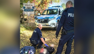 This handout picture taken and released by Policja Mazowsze on October 7, 2026, shows two policemen detaining a suspected high school knife attacker in the town of Ostroleka, some 130 km north of Warsaw. Photo by Handout / Policja Mazowsze / AFP