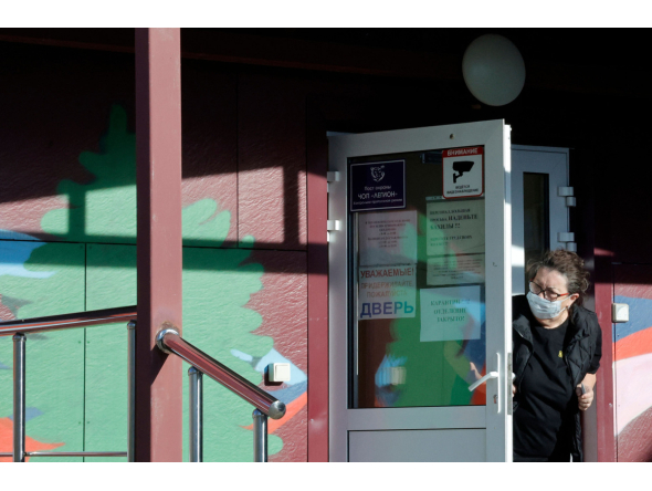 A security person wearing a face mask looks out from the door of an infectious diseases hospital in the town of Shelekhov, where an employee of the Irkutsk Antiplague Research Institute had died, in the Irkutsk region on October 7, 2026. (Photo by TATYANA MAKEYEVA / AFP)