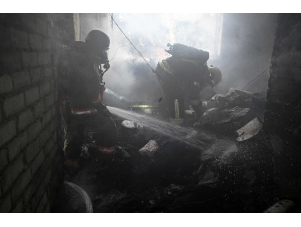 Firefighters operate to extinguish a fire inside a clinic building after a Russian aerial attack on Kharkiv on October 10, 2026. (Photo by Sergey Bobok / AFP)