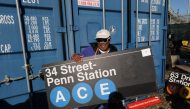Film director Spike Lee holds a subway sign as people take home a piece of New York City's transportation system on October 9, 2026. Photos by Timothy A Clary / AFP
