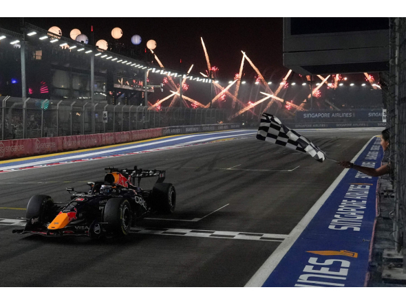 Red Bull Racing's Dutch driver Max Verstappen crosses the chequered flag at the finish line to win the Formula One Singapore Grand Prix at the Marina Bay Street Circuit in Singapore on October 11, 2026. (Photo by Ng Han Guan / POOL / AFP)