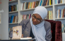 Aisha Al-Idrissi signs a copy of her book for a visitor.