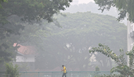This picture provided by The Straits Times taken and received on October 14, 2026 shows a man walking on a road as the city is shrouded with haze in Singapore. (Photo by The Straits Times / AFP)