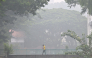 This picture provided by The Straits Times taken and received on October 14, 2026 shows a man walking on a road as the city is shrouded with haze in Singapore. (Photo by The Straits Times / AFP)
