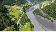 An aerial view shows muddy water flowing through the Budhi Gandaki river, separating Nepal's Gorkha (L) and Dhading districts on October 14, 2026, in the aftermath of a flash flood caused by a dry landslide. (Photo by Prakash Mathema / AFP)