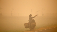 A person takes photos amid thick haze caused by forest and peatland fires in Palangka Raya, Central Kalimantan, Indonesia, Oct. 13, 2026. (Photo by Regina Safri/Xinhua)