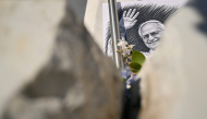 A drawing of Pope Leo XIV is laid at the statue of John Paul II outside the Gemelli University Hospital in Rome on October 16, 2026 (Photo by Alberto Pizzoli / AFP)