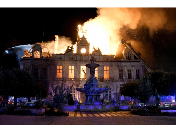 This photograph shows a fire burning and destroying the city hall after a group of individuals forced entry into the building in Limoges, central France on October 17, 2026. (Photo by Pascal Lachenaud / AFP)
