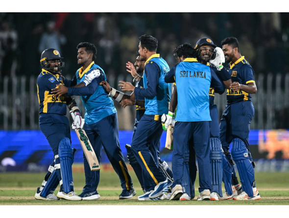 Sri Lanka's players celebrate after their victory in the one-day international (ODI) tri-series cricket match between England and Sri Lanka at the Rawalpindi Cricket Stadium in Rawalpindi on October 22, 2026. (Photo by FAROOQ NAEEM / AFP)