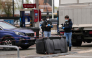 Police officers look at evidences on a site of a petrol station where a man opened fire from his car, killing one person and injuring four others according to police sources, in Trappes, Paris' suburb on October 23, 2026. Photo by Dimitar DILKOFF / AFP