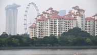 People row a canoe along the Kallang river as the haze eases in Singapore on October 23, 2026. (Photo by Roslan RAHMAN / AFP)