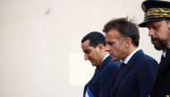 French President Emmanuel Macron (C) walks with Mayor of Trappes Ali Rabeh (L) during a visit following a shooting in Trappes, near Paris on October 23, 2026. (Photo by Hannah McKay / POOL / AFP)
