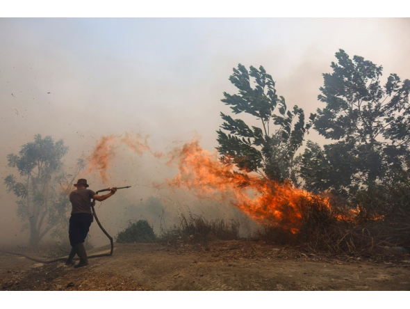 A firefighter battles a fast-moving brush fire amidst heavy smoke in Tegal Arum, Banjarbaru, South Kalimantan, on October 20, 2026. Photo by MUDA SAGALA / AFP