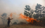 A firefighter battles a fast-moving brush fire amidst heavy smoke in Tegal Arum, Banjarbaru, South Kalimantan, on October 20, 2026. Photo by MUDA SAGALA / AFP