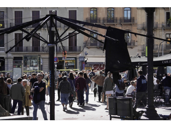 People walk past a burnt sunshade on a terrace damaged during overnight riots in Catalunya square in Barcelona, on October 25, 2026. (Photo by Manaure Quintero / AFP)
 