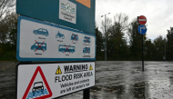 A flood warning sign is seen beside the River Eden in Carlisle in north-west England on October 25, 2026, as Storm Boelo brings strong winds and heavy rain across much of northern England. (Photo by Andy Buchanan / AFP)