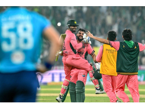 Pakistan's Shadab Khan (2L) and Haris Rauf (L) celebrate after their team's victory in the one-day international (ODI) tri-series cricket match against England at the Gaddafi Stadium in Lahore on October 25, 2026. (Photo by ARIF ALI / AFP)