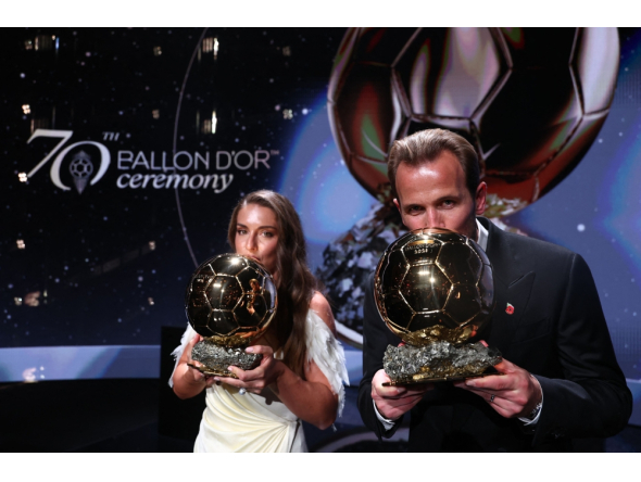 Spain and Barcelona midfielder Alexia Putellas and England and Bayern Munich forward Harry Kane kiss their trophies on stage after receiving their Ballon d'Or awards on October 26, 2026. (Photo by Franck Fife / AFP)
