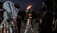 A torchbearer carries the Youth Olympic Flame on the eve of the opening ceremony of the Youth Olympic Games in Dakar on October 30, 2026. (Photo by Patrick Meinhardt / AFP)