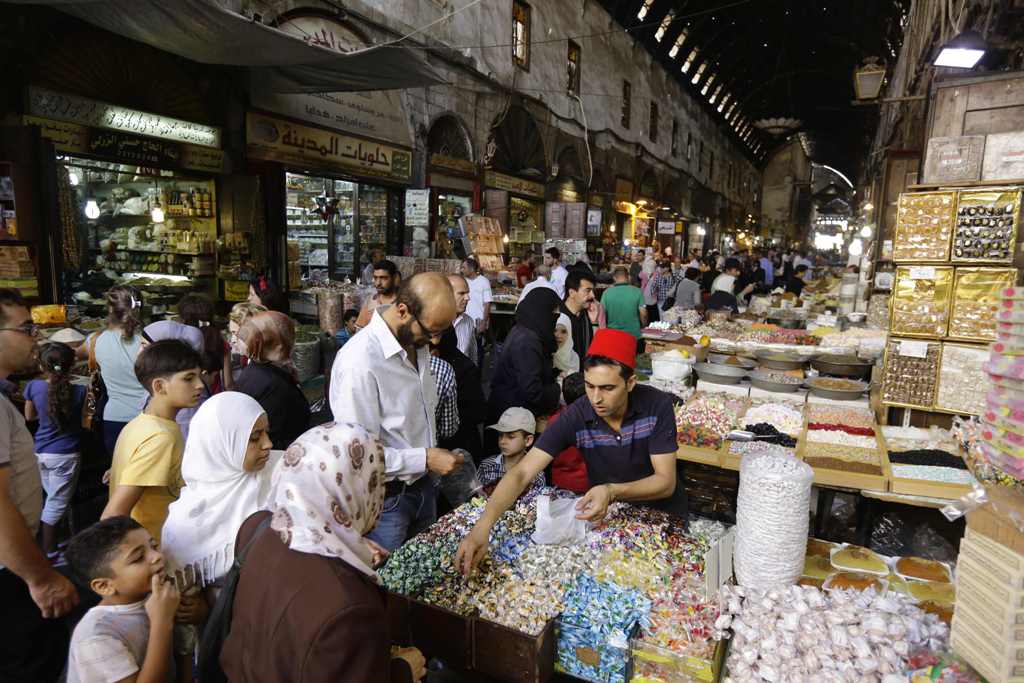 Syrians shop at the Hamidiyeh popular market in the old part of the capital Damascus as they prepare for the Muslim Eid al-Adha holiday on September 11, 2016. / AFP / LOUAI BESHARA