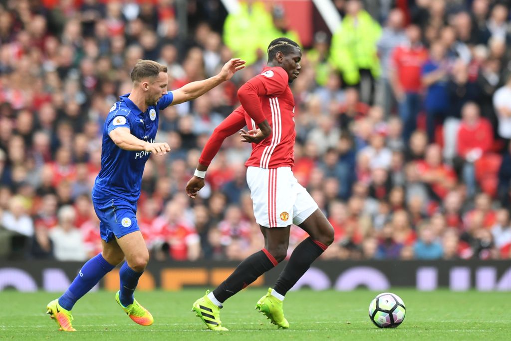 Manchester United's French midfielder Paul Pogba (R) holds off Leicester City's English midfielder Danny Drinkwater (L) during the English Premier League football match between Manchester United and Leicester City at Old Trafford in Manchester, north west