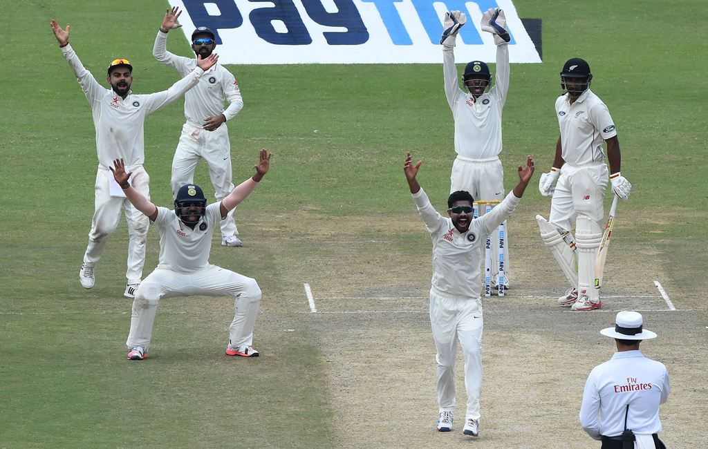 India's Ravindra Jadeja (C) appeals successfully for LBW for the wicket of Zealand's Ish Sodhi (2R) with captain Virat Kohli (L) and other teammates during the third day of the first Test match between India and New Zealand at Green Park Stadium in Kanpur