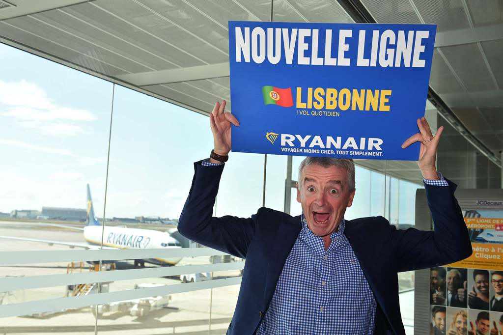 Ryanair chief executive Michael O'Leary gestures as he holds a sign reading 'New lines' during a press conference on new flights from Toulouse at the Toulouse-Blagnac airport on September 27, 2016. (AFP / Remy GABALDA)