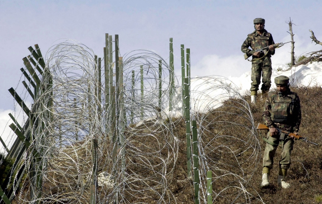 This file photograph shows Indian soldiers as they patrol along a barbed-wire fence near Baras Post on the Line of Control (LoC) between Pakistan and India some 174 kms north west of Srinagar. AFP / SAJJAD HUSSAIN