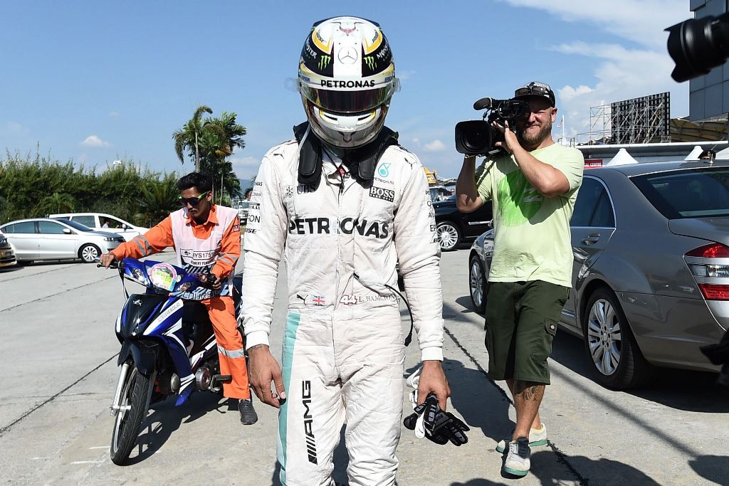 Mercedes AMG Petronas F1 Team's British driver Lewis Hamilton is driven back to the pit, after his car caught fire during the Formula One Malaysian Grand Prix in Sepang on October 2, 2016. (AFP / MANAN VATSYAYANA)