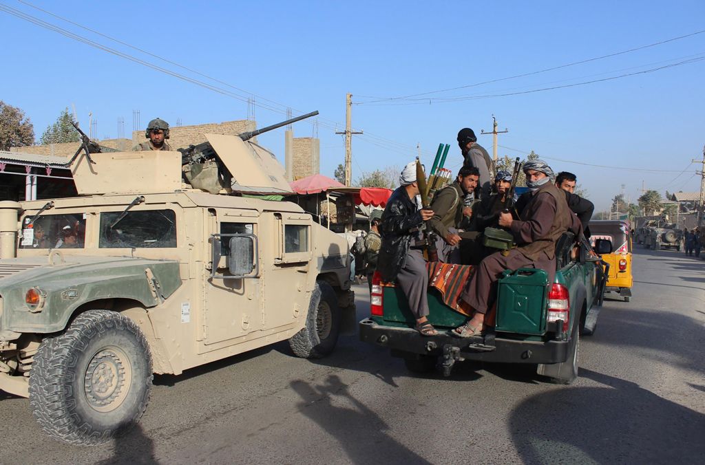 Afghan militia forces sit in a police vehicle amid ongoing fighting between Taliban militants and Afghan security forces in Kunduz on October 4, 2016. AFP / BASHIR KHAN SAFI