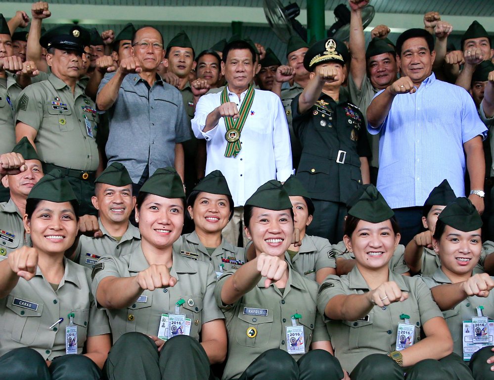Philippines President Rodrigo Duterte (C) clenches fist with members of the Philippine Army during his visit at the army headquarters in Taguig city, metro Manila, Philippines October 4, 2016. (Reuters / Romeo Ranoco)