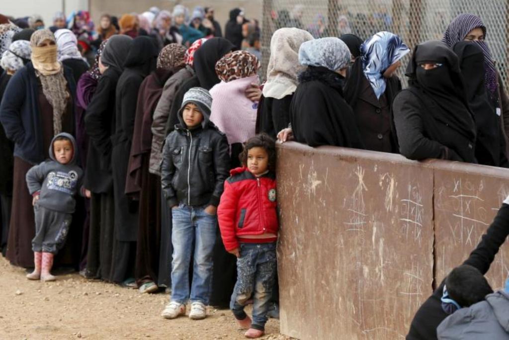 Syrian refugees stand in line as they wait for aid packages at Al Zaatari refugee camp in the Jordanian city of Mafraq, near the border with Syria, January 20, 2016. REUTERS/ Muhammad Hamed.