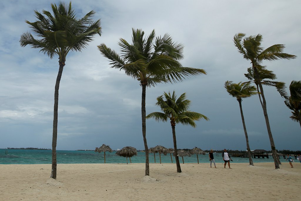 People walk along a beach in the wind in advance of Hurricane Matthew in Nassau, Bahamas October 5, 2016. REUTERS/Carlo Allegri

