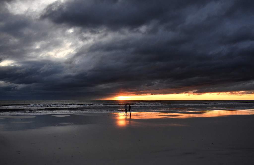 A couple watch the sunrise in Jacksonville Beach, Florida, on October 8, 2016, after Hurricane Matthew passed the area. AFP / Jewel SAMAD
