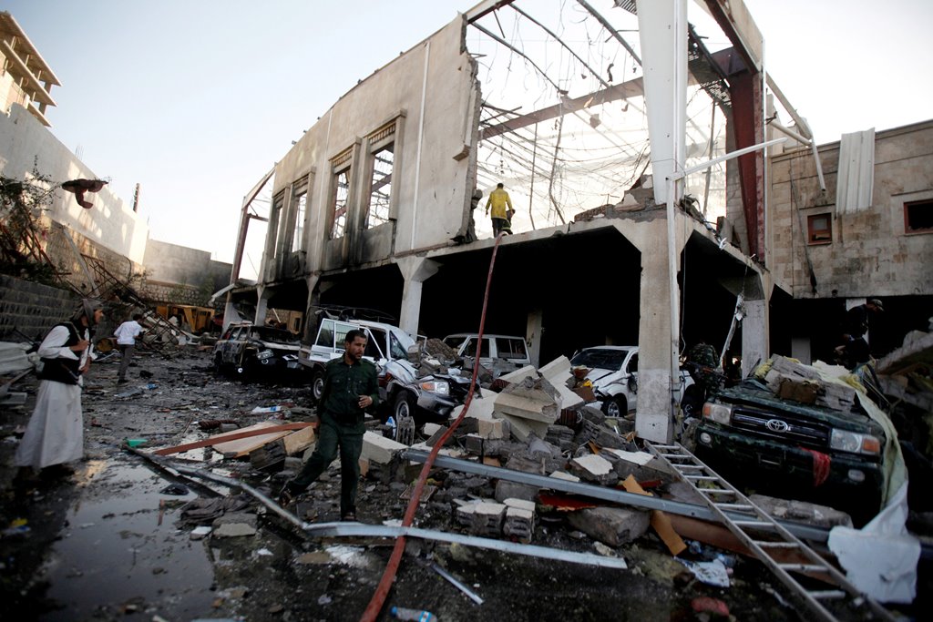 People stand at the site of an airstrike which witnesses said was by Saudi-led coalition aircraft on mourners at a hall in the Houthi-dominated Yemeni government, was being held, in Sanaa, Yemen October 8, 2016. Reuters/Khaled Abdullah