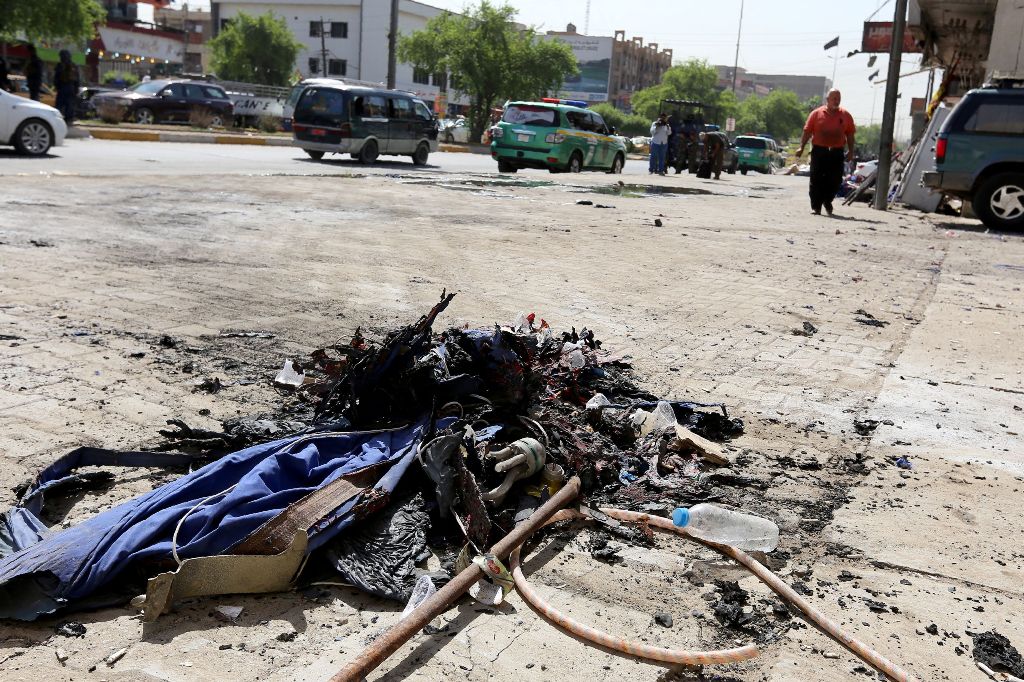 The remains from an explosion attack, which targeted an Ashura procession commemorating the death of Imam Hussain, the grandson of Prophet Muhammad, are seen on the ground in the Iraqi capital Baghdad on October 9, 2016. / AFP / SABAH ARAR