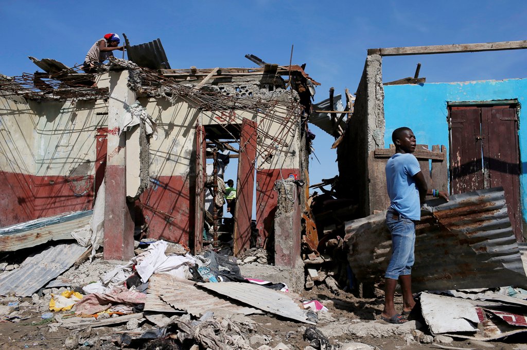 Men salvage metal sheets from a destroyed house after Hurricane Matthew passes in Jeremie, Haiti, October 8, 2016. REUTERS/Carlos Garcia Rawlins
