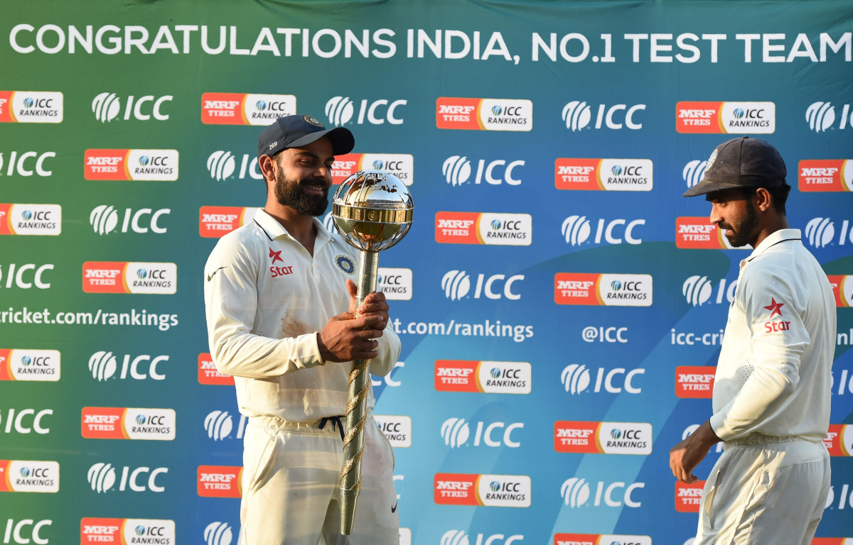 India's Test cricket team captain Virat Kohli holds the ICC Number 1 Test cricket team trophy after winning the three Test cricket match series against New Zealand at the Holkar Cricket Stadium in Indore on October 11, 2016. (AFP / Punit Paranjpe)