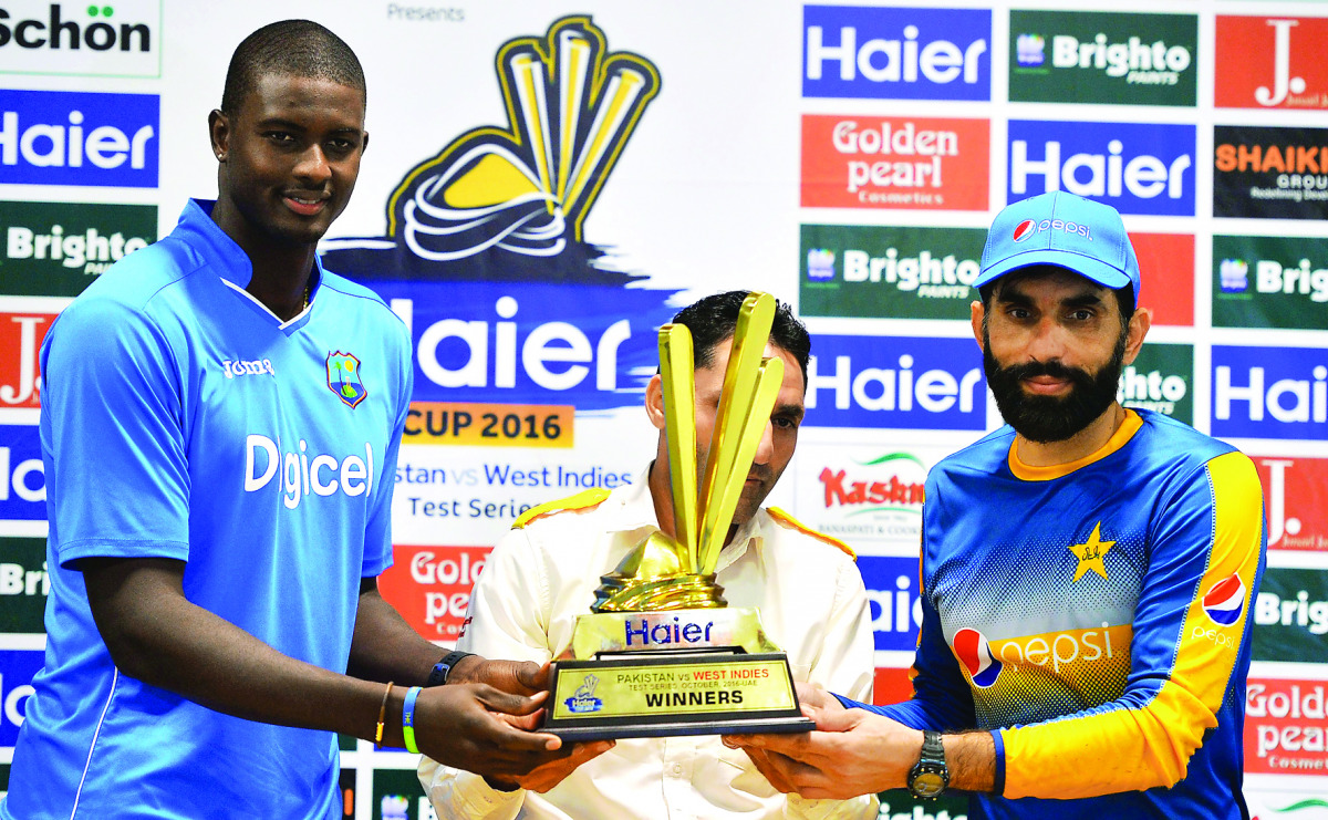 Pakistani cricket captain Misbah-Ul-Haq (right) and his West Indies counterpart Jason Holder hold the Test series trophy at the Dubai International Cricket Stadium in the Gulf Emirate, in the UAE
