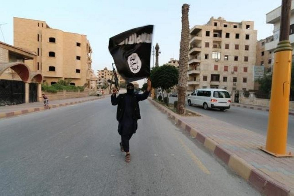 A member loyal to the Islamic State waves an ISIS flag in Raqqa.  (Reuters / File photo)