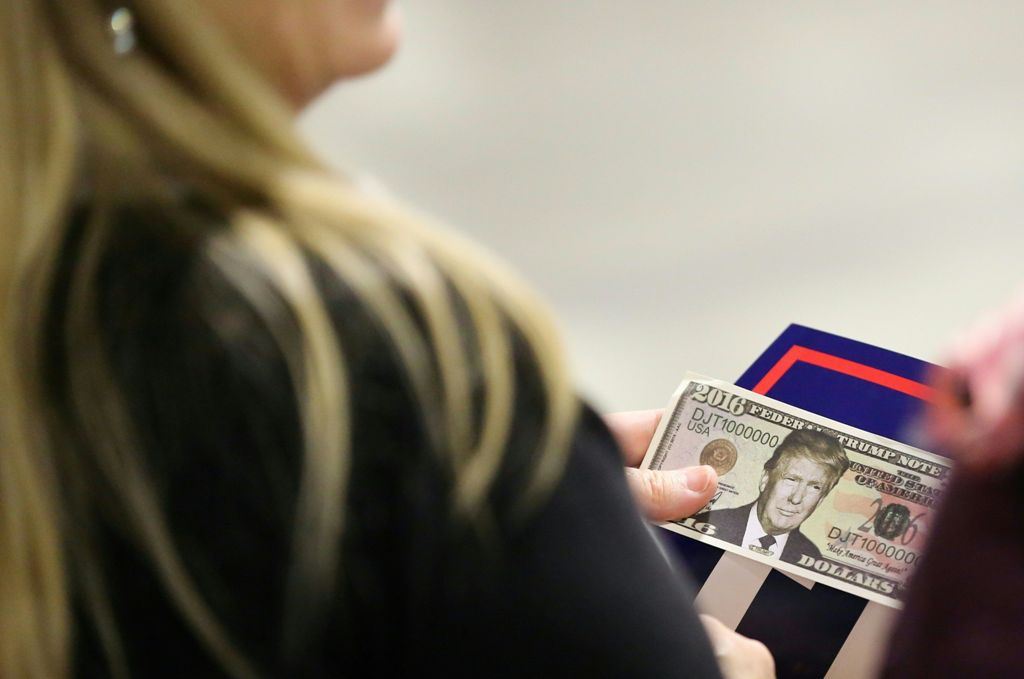 A woman holds fake money with Republican Presidential Candidate Donald Trump's face on it before the start of his rally at the Convention Center in Charlotte, North Carolina on October 14, 2016. / AFP / Logan Cyrus