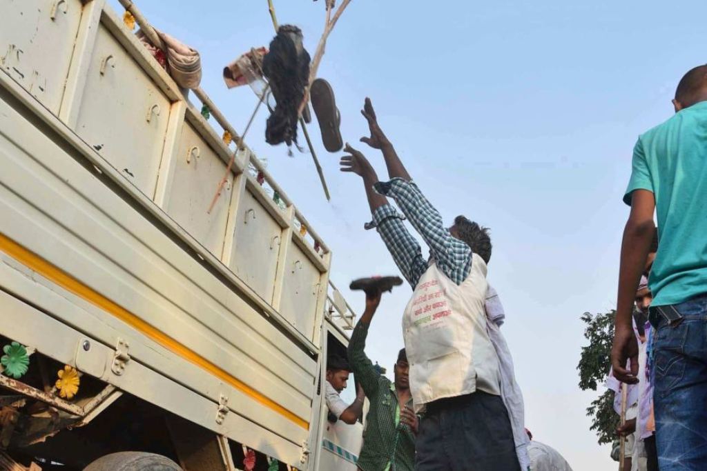 A man loads a truck with footwear of victims of a stampede on a crowded bridge on the outskirts of Varanasi. / AP