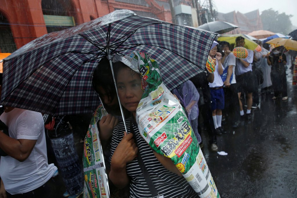 Mourners gather in the rain outside the Grand Palace as they wait to pay their respects to the late King Bhumibol Adulyadej in Bangkok, Thailand October 16, 2016. REUTERS/Edgar Su
